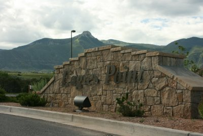 A stone sign reads "Eagle Point" with mountains in the background under a cloudy sky.