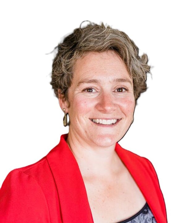 Image of BCLD board member Jacque Cobb , smiling with short, curly hair, wearing a red blazer over a dark top, against a white background.