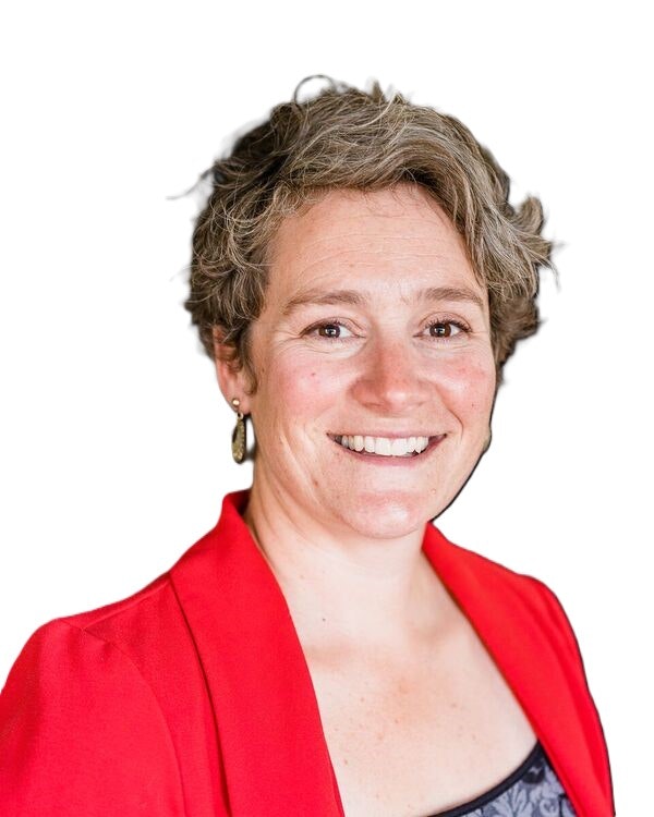 Image of BCLD board member Jacque Cobb , smiling with short, curly hair, wearing a red blazer over a dark top, against a white background.