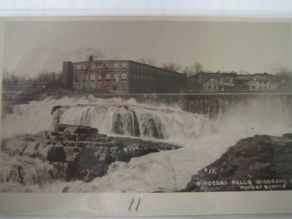 Waterfall with adjacent industrial building and houses, labeled "Winooski Falls, Winooski."
