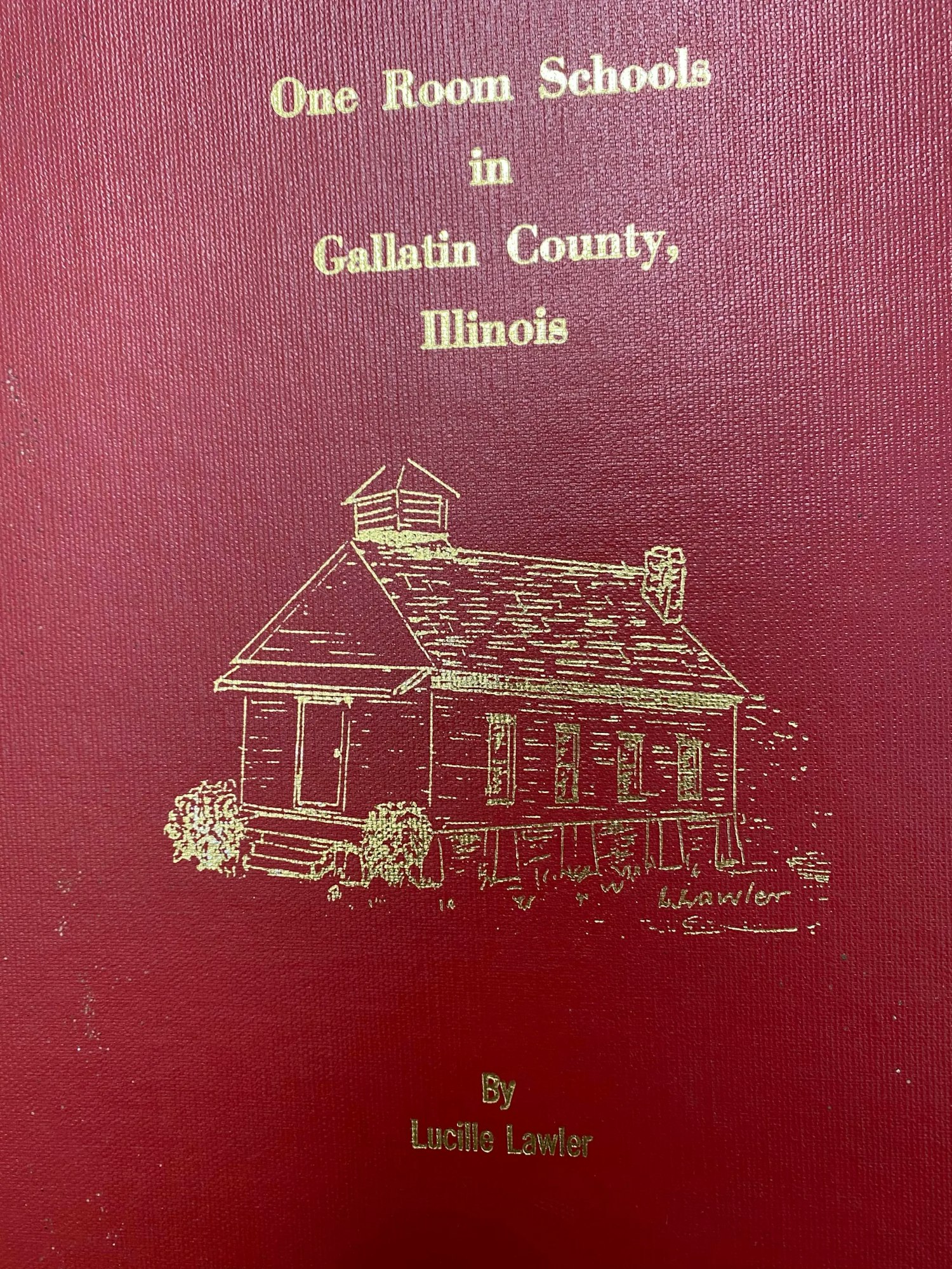 Book cover titled "One Room Schools in Gallatin County, Illinois" by Lucille Lawler, with an illustration of a schoolhouse.