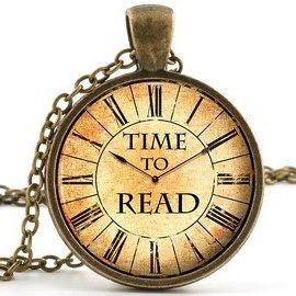 A vintage pocket watch pendant with the words "TIME TO READ" on its face.