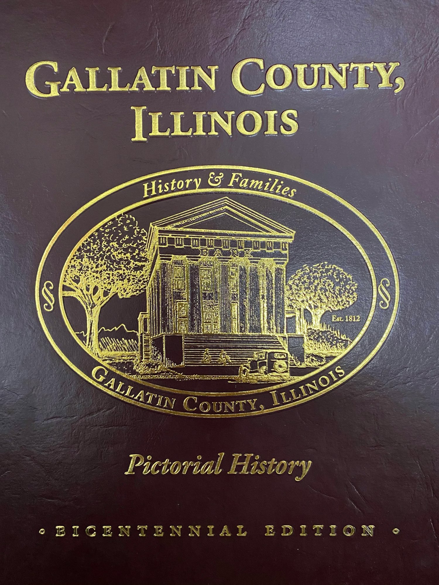 Cover of a book titled "Gallatin County, Illinois: History & Families, Pictorial History, Bicentennial Edition" with a building illustration.