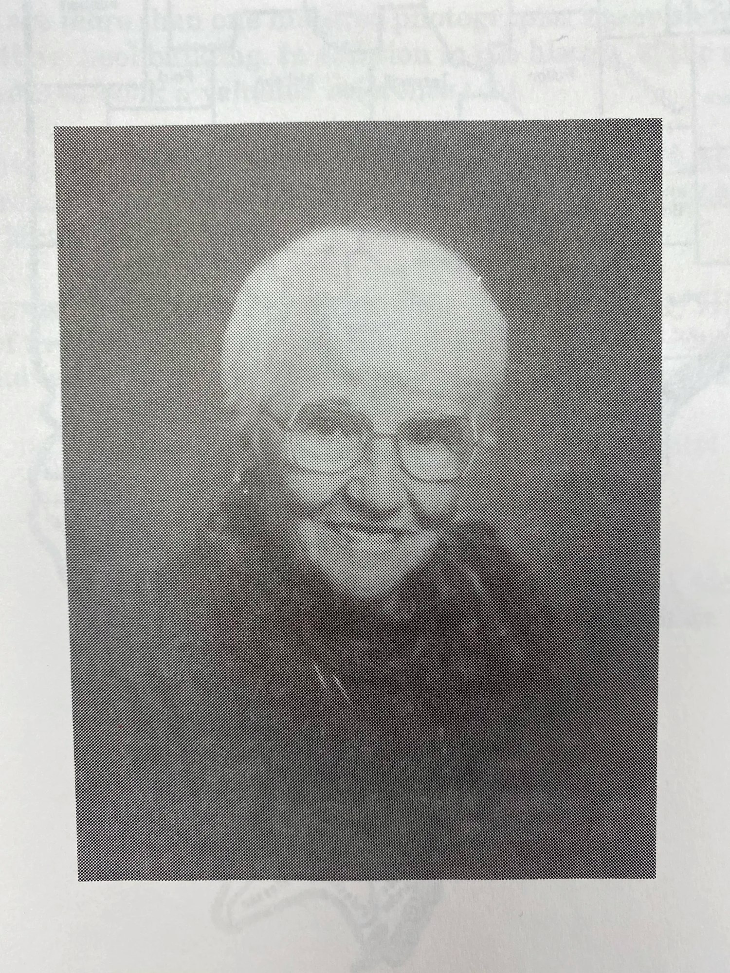 A black and white photo of an older person wearing glasses and smiling.