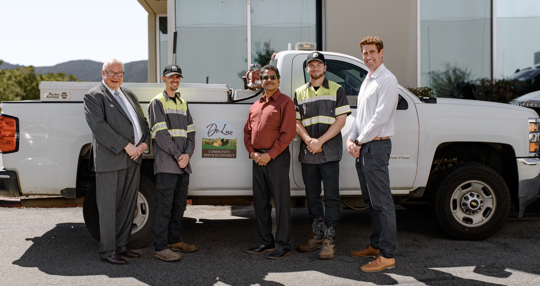 May contain: clothing, footwear, shoe, accessories, glasses, adult, male, man, person, hat, formal wear, tie, pickup truck, transportation, truck, vehicle, groupshot, and belt