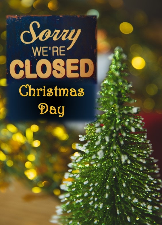 A "Sorry, we're closed" sign for Christmas Day, with a decorated Christmas tree.
