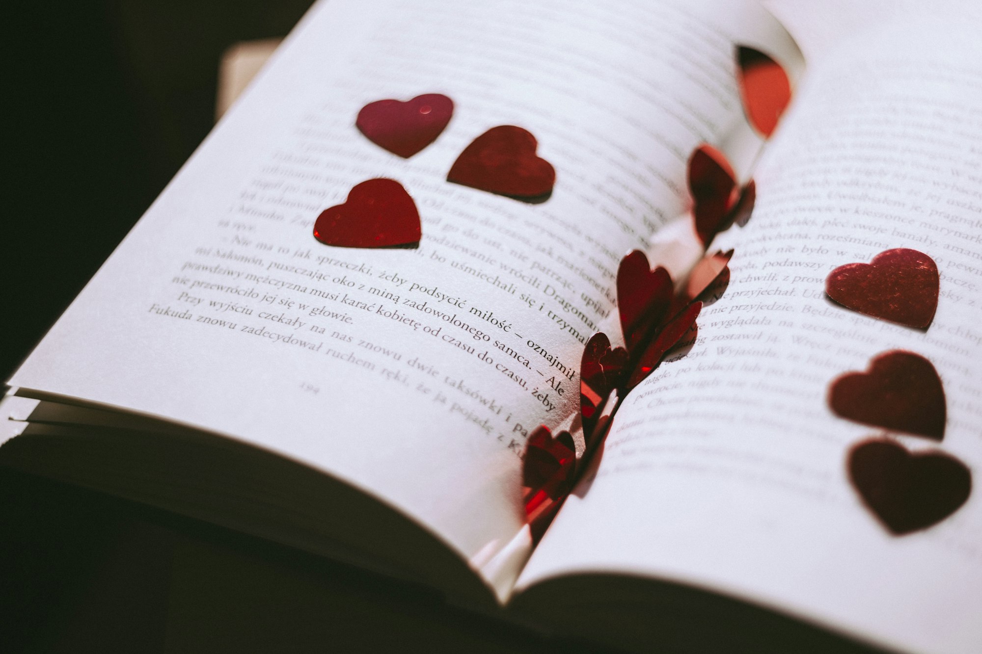 A book, with red paper hearts scattered around it