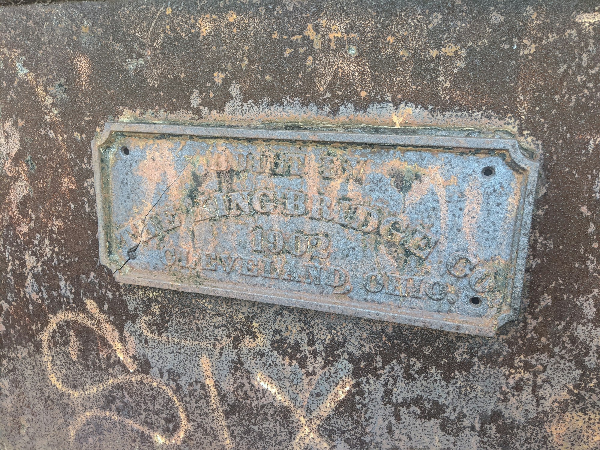 Rusty plaque on metal surface, reads "King Bridge Co., 1902, Cleveland, Ohio."