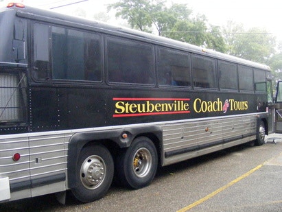 A black bus with "Steubenville Coach Tours" written on the side, parked outdoors.