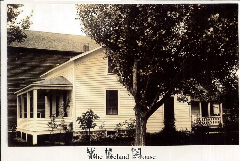 The image shows a historic house named "The Leland House," with a porch and surrounded by trees and greenery.