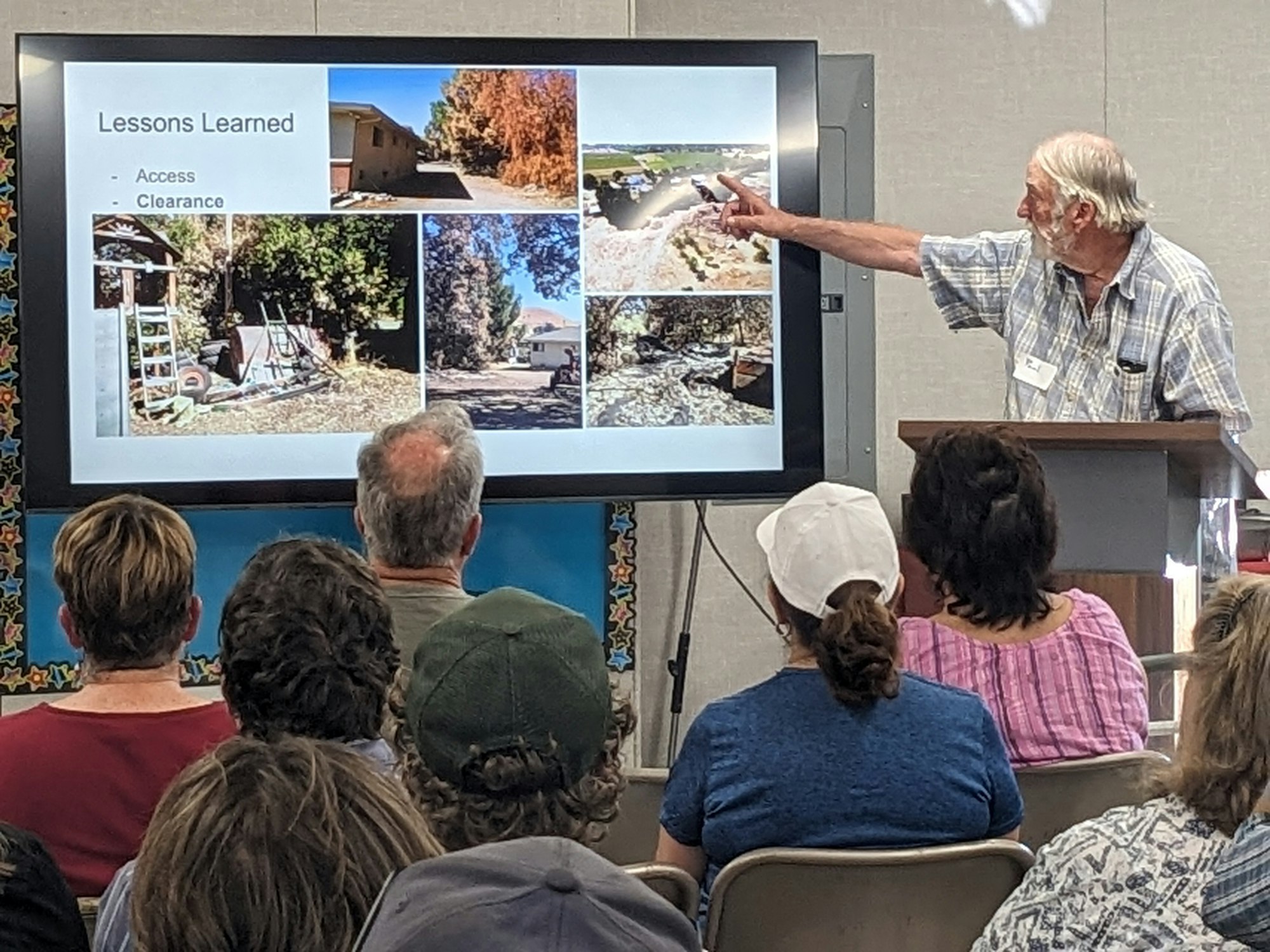 A person is giving a presentation to an audience, pointing at a slide with images and text labeled "Lessons Learned."