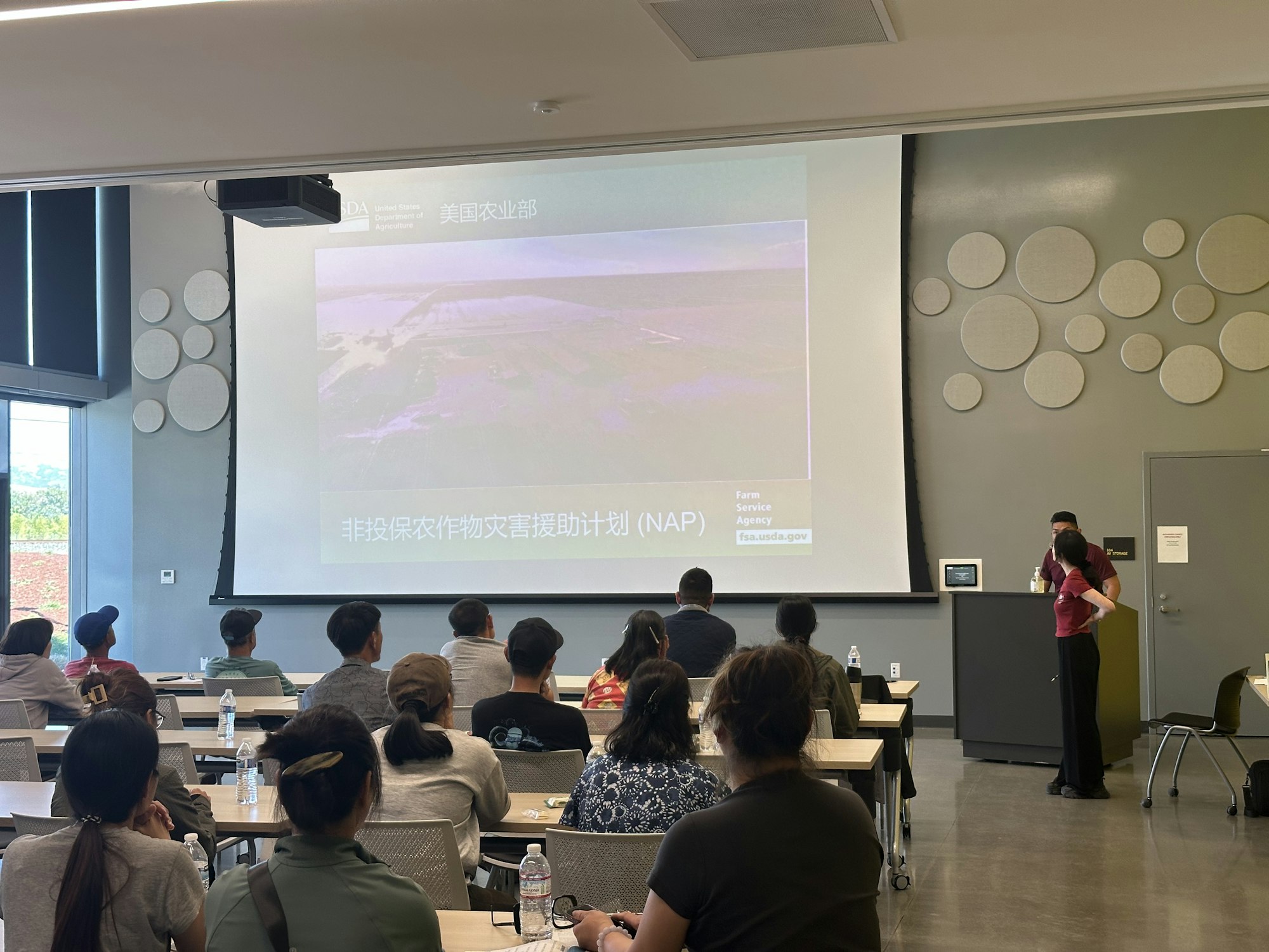 People in a classroom attending a presentation about the USDA's Non-Insured Crop Disaster Assistance Program (NAP).