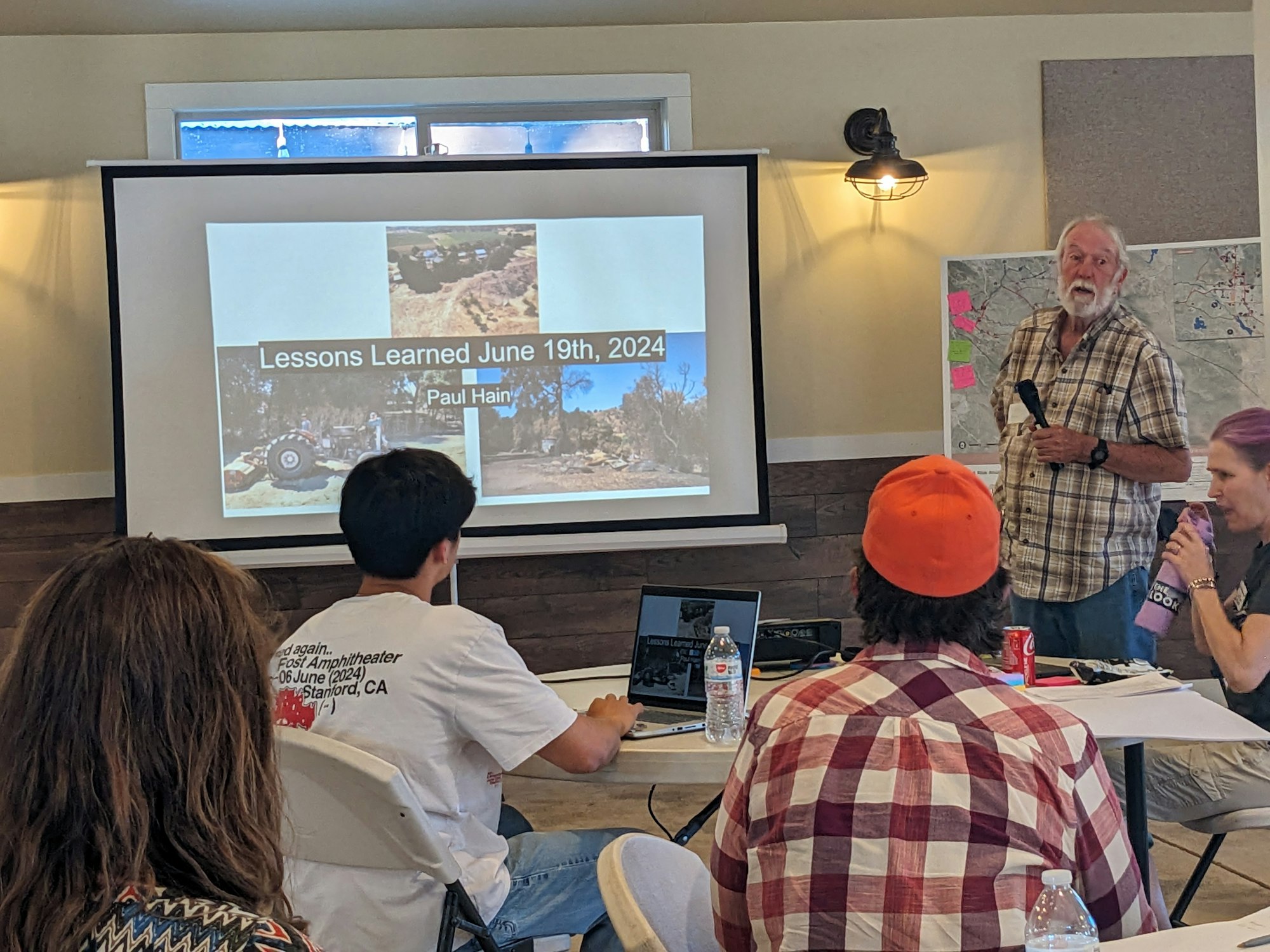 A presentation titled "Lessons Learned June 19th, 2024" in progress with the speaker and audience visible.