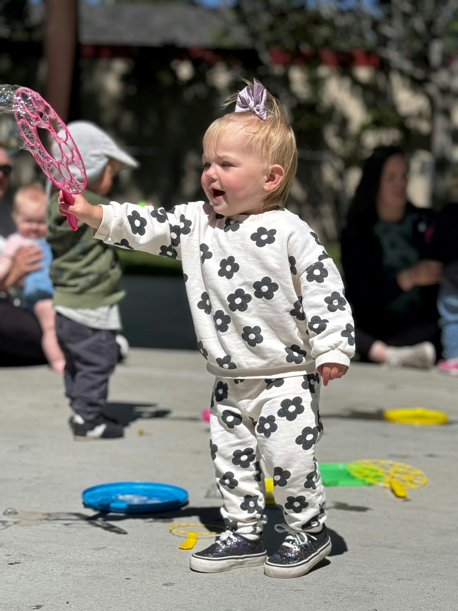 Toddler playing with a bubble toy outside.