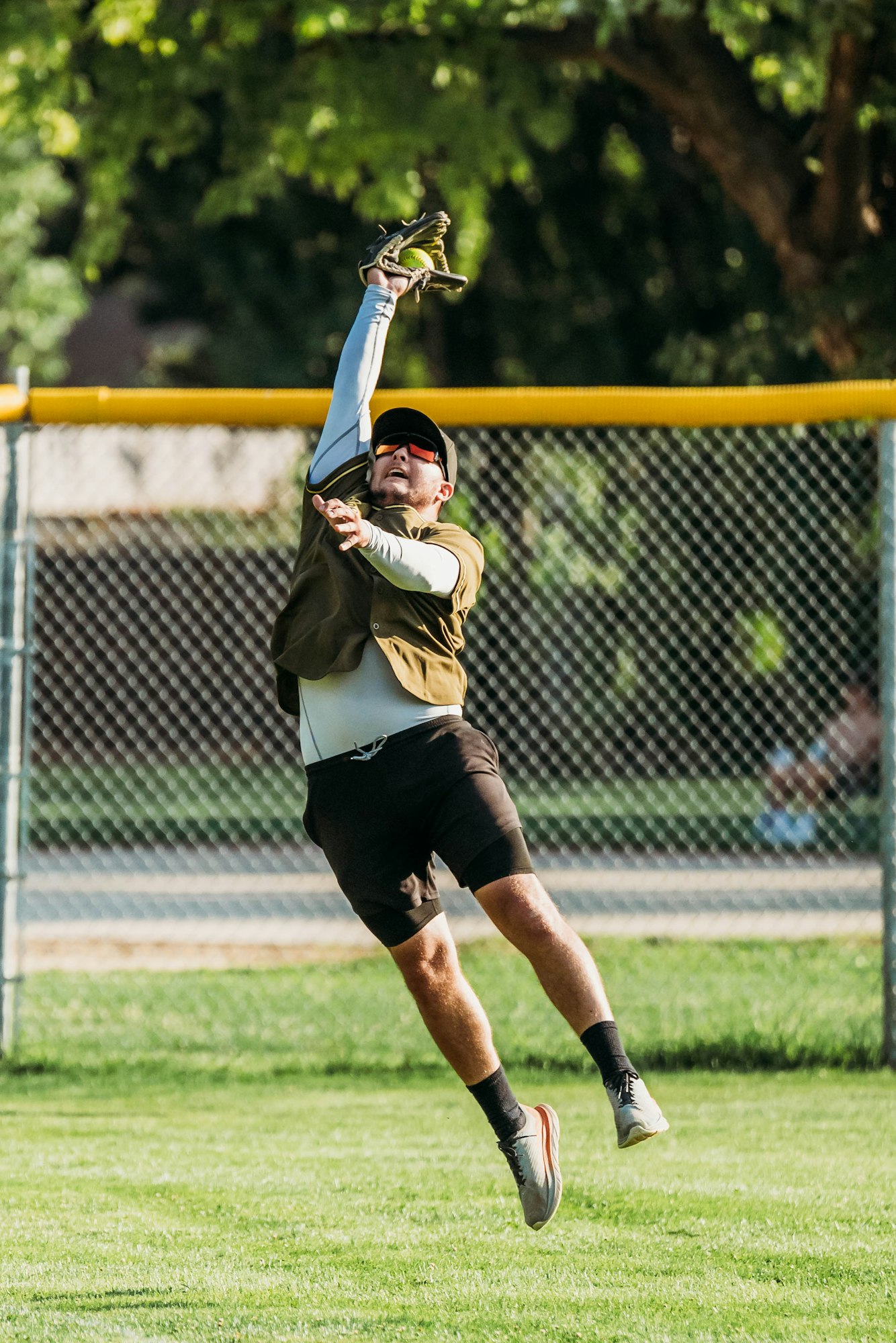 A baseball player leaping to catch a ball.