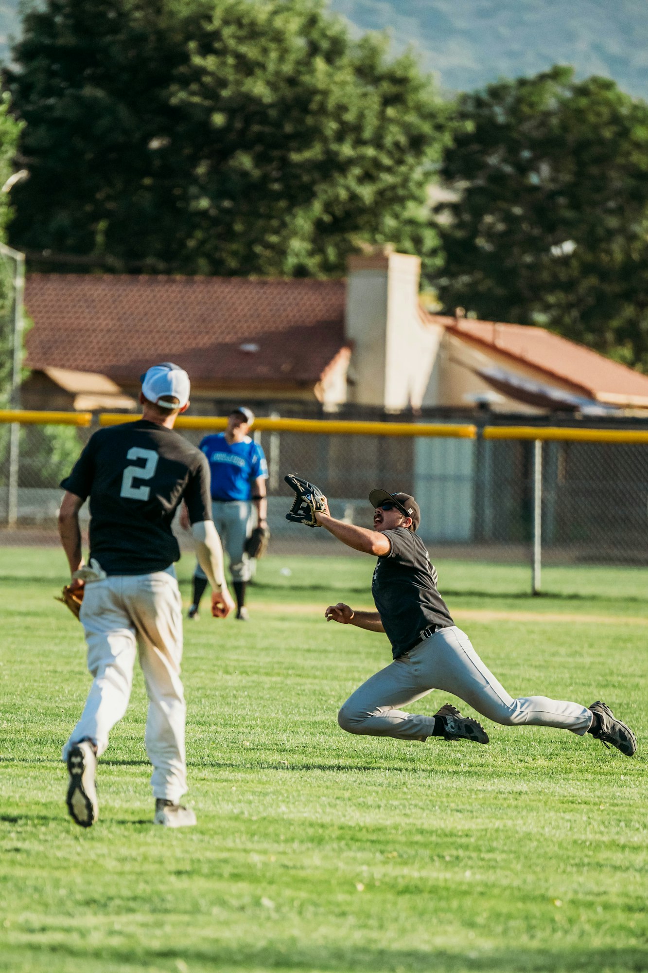 Baseball players in action on a field, with one catching a ball.