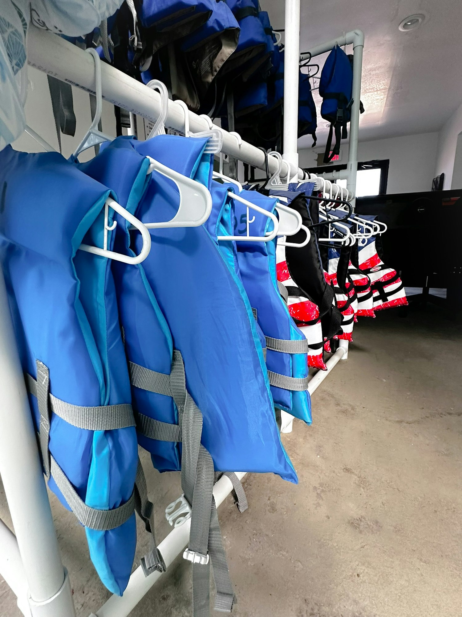 Life jackets hanging on a rack.