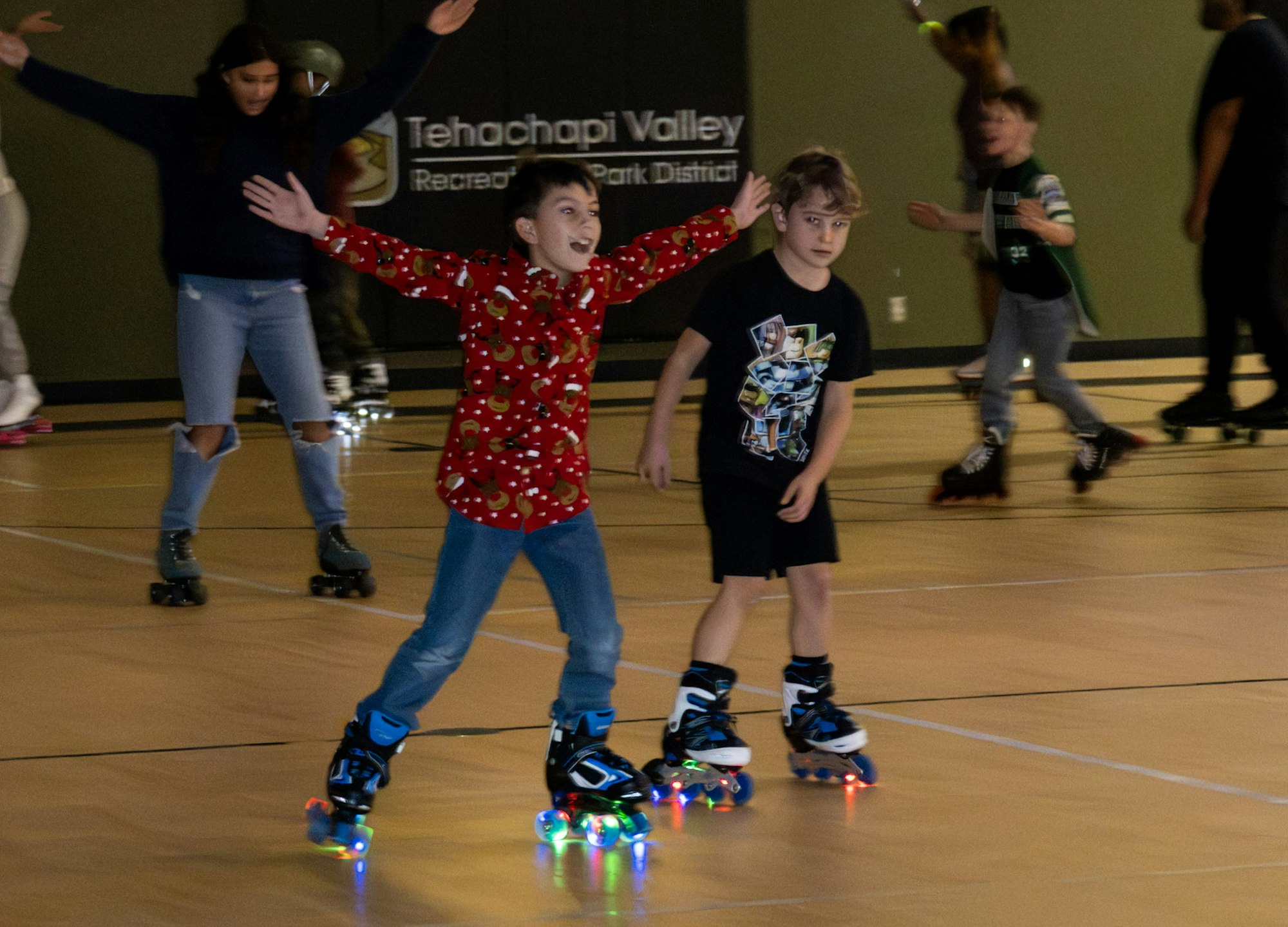 A lively roller skating rink scene with kids enjoying skating, including one boy in a festive shirt with colorful roller skates.