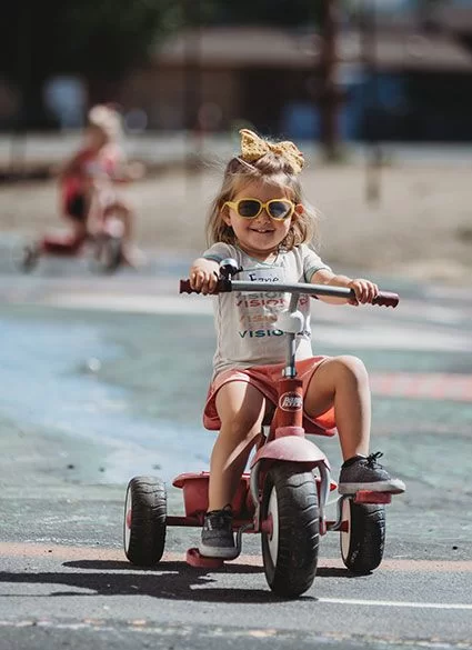 May contain: e-scooter, transportation, vehicle, child, female, girl, person, tricycle, clothing, and shorts