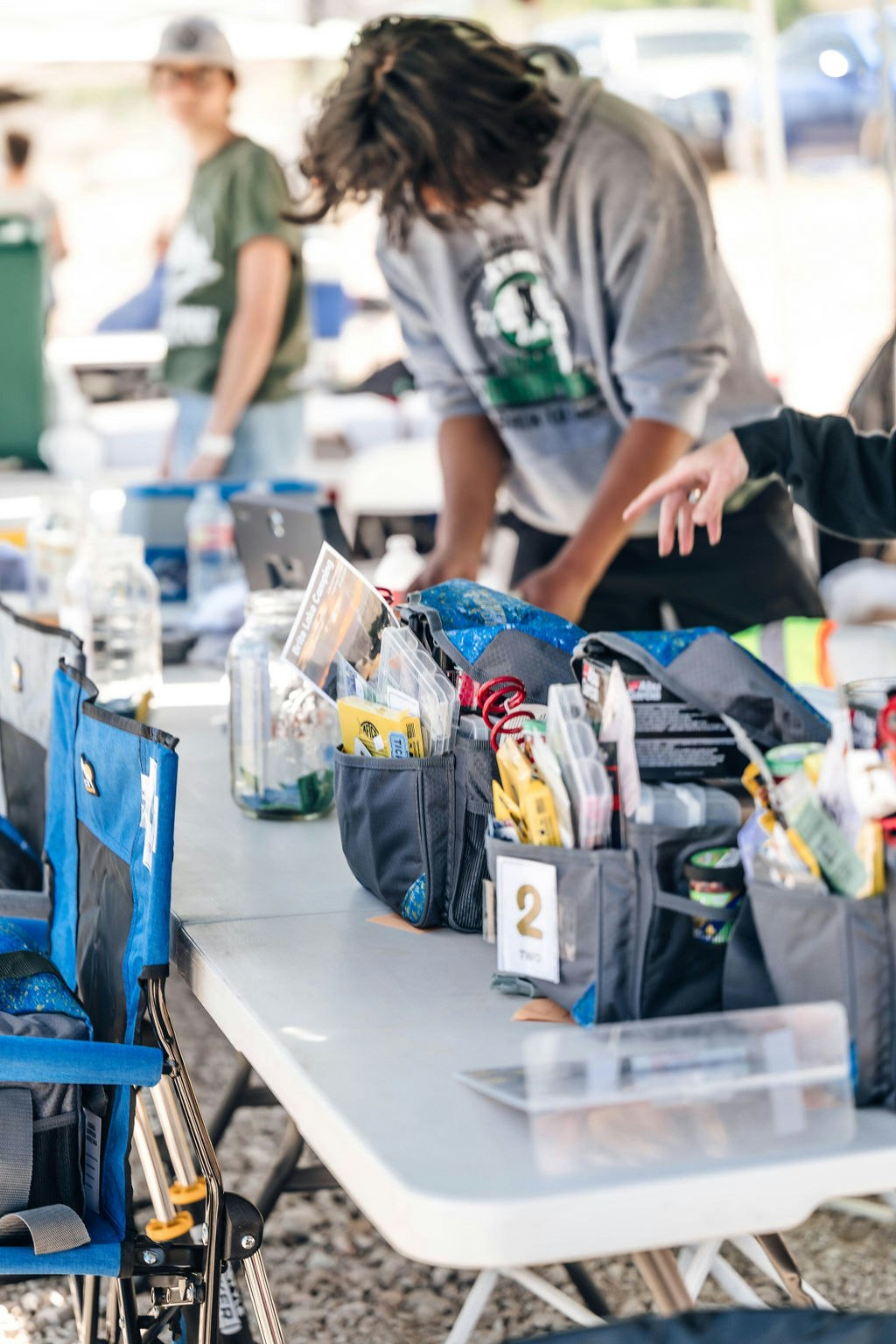 People at a table with organizational tools, possibly at a community or work event.