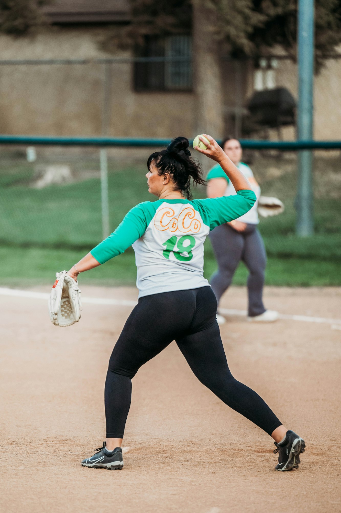 A woman pitches a softball on a dusty field, teammate in the background. #sports #softball #pitching