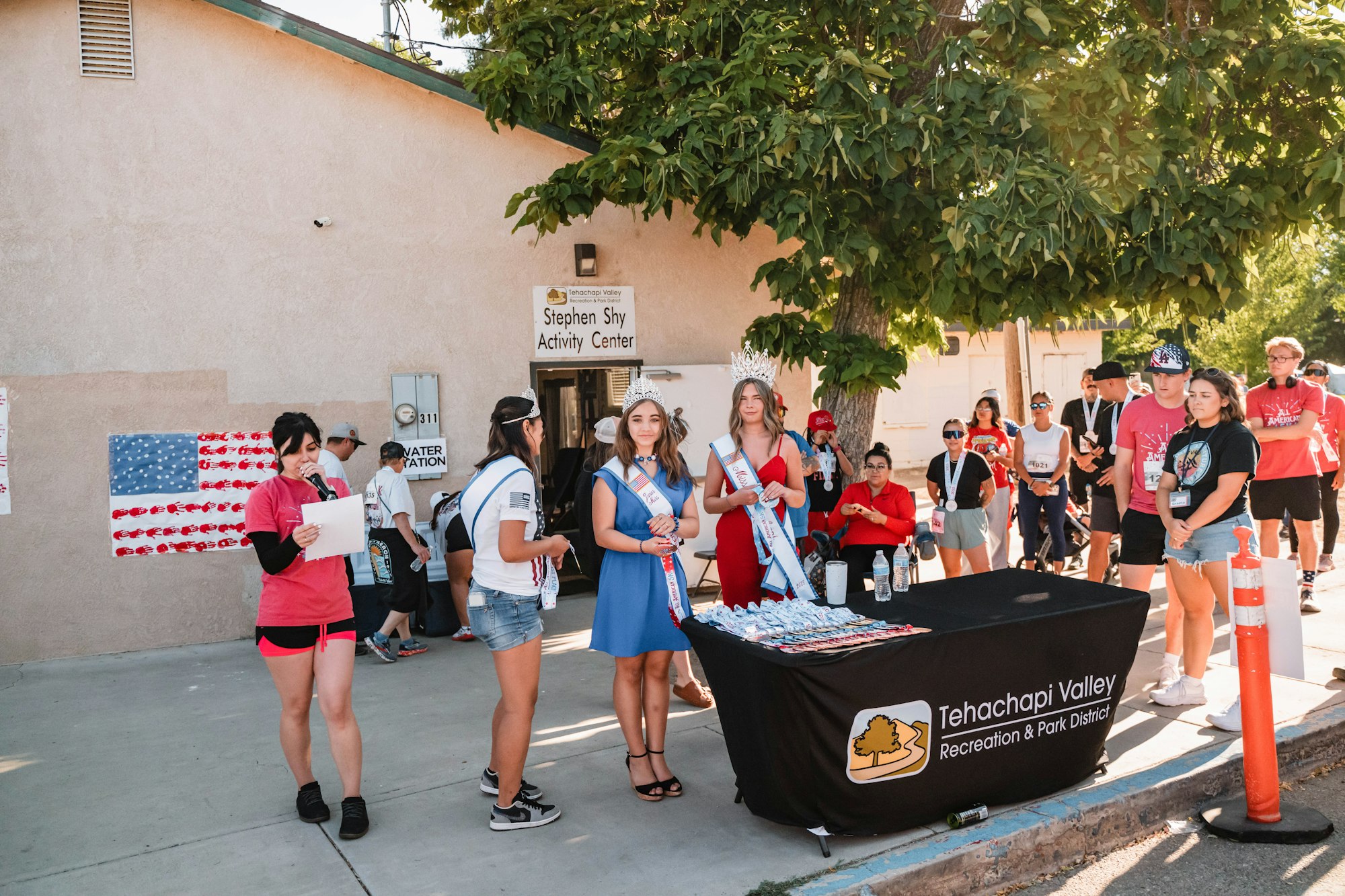 A group of people gathered near the Stephen Shy Activity Center, with a table from Tehachapi Valley Recreation & Park District.