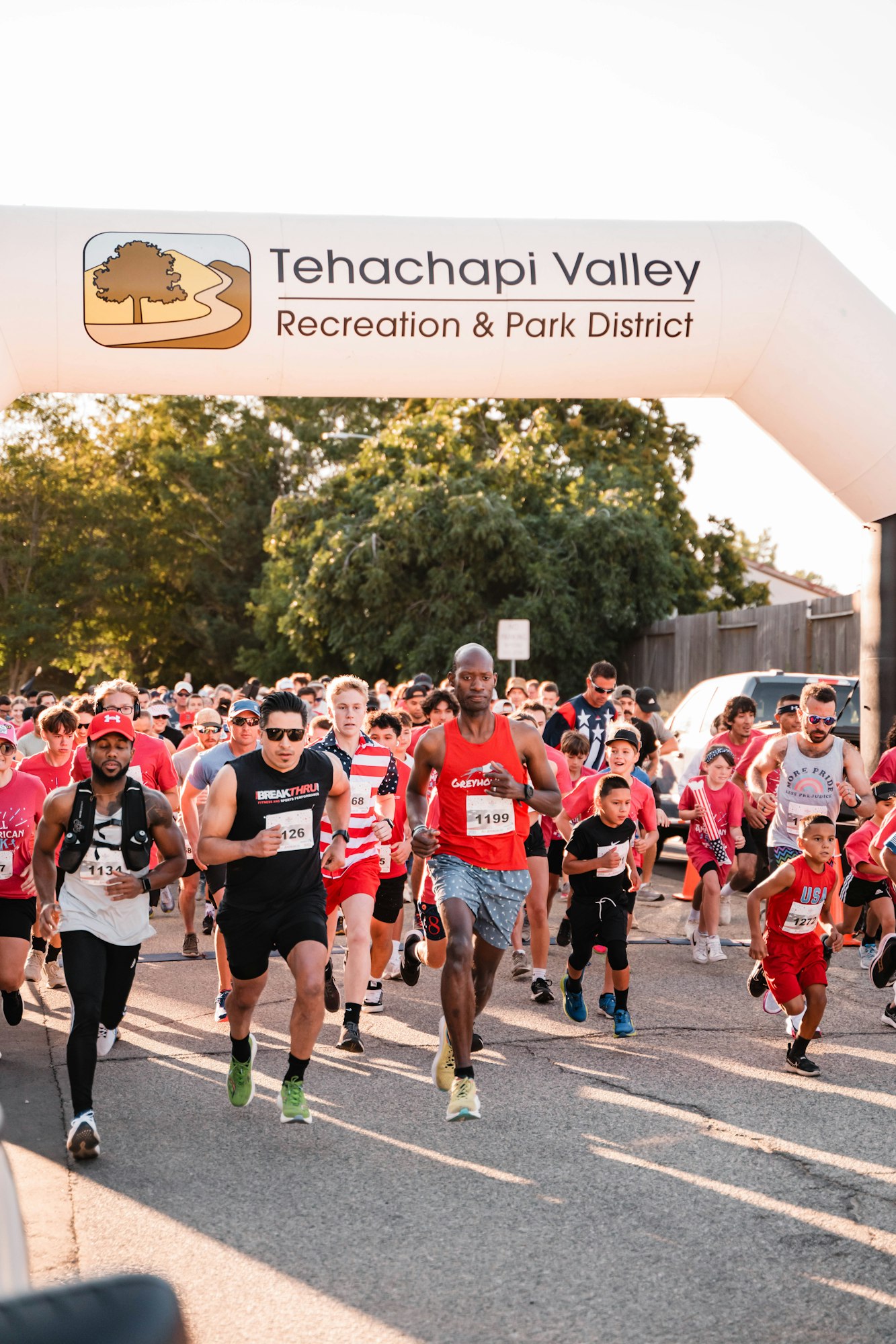 A group of runners starting a race under a banner for Tehachapi Valley Recreation & Park District.
