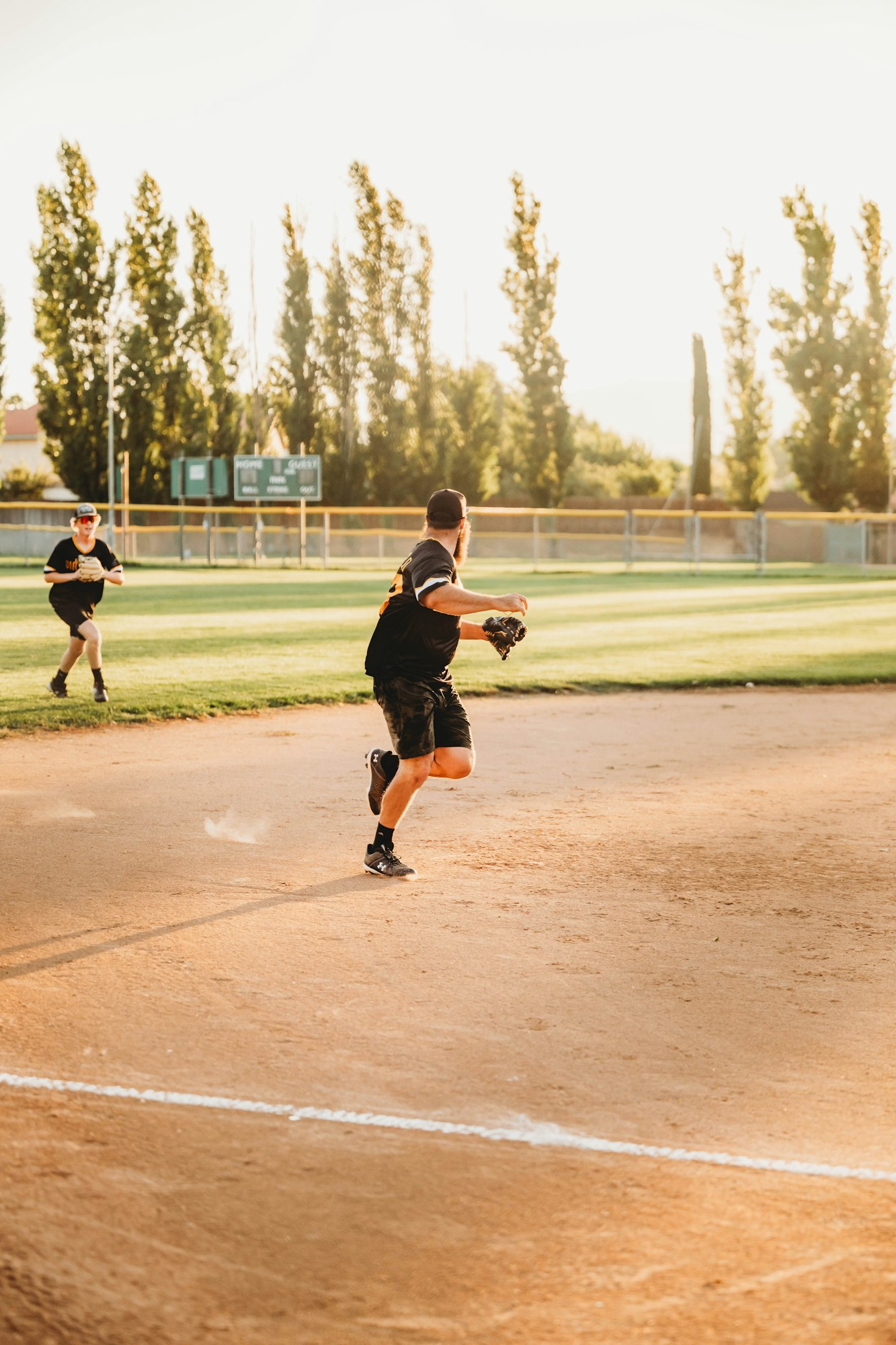 Two people playing baseball on a field.