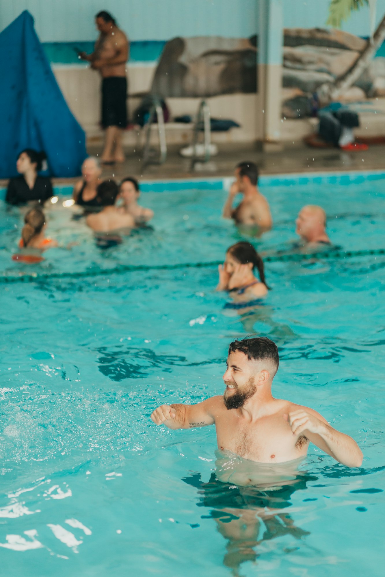 People swimming and relaxing in an indoor pool.