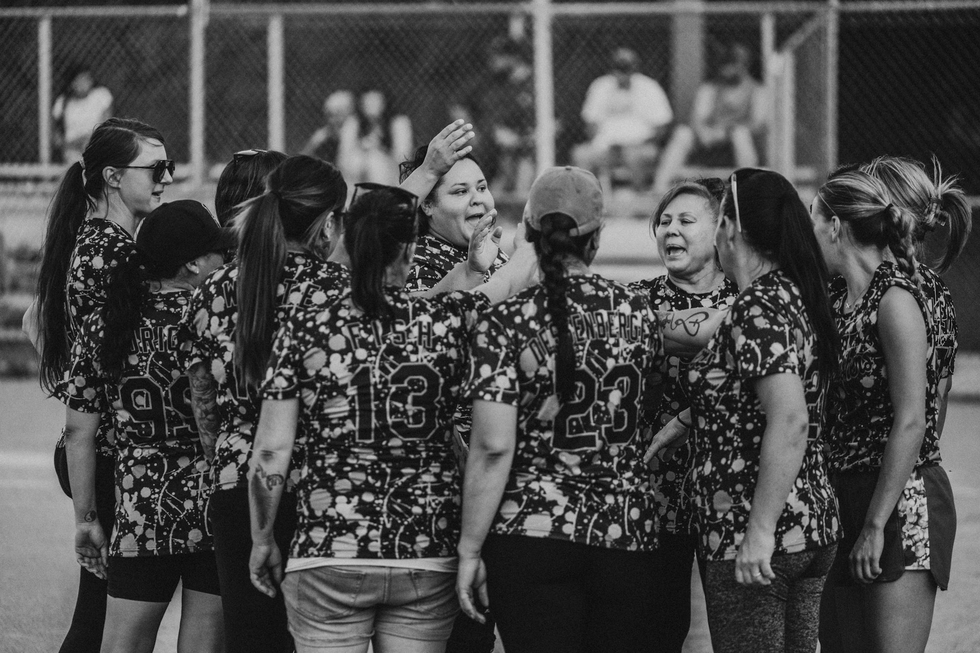 A black and white photo of a softball team celebrating with high-fives.