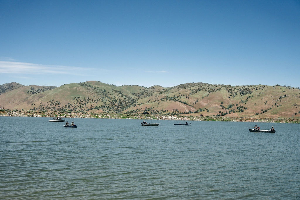A lake with boats and a hilly landscape in the background.