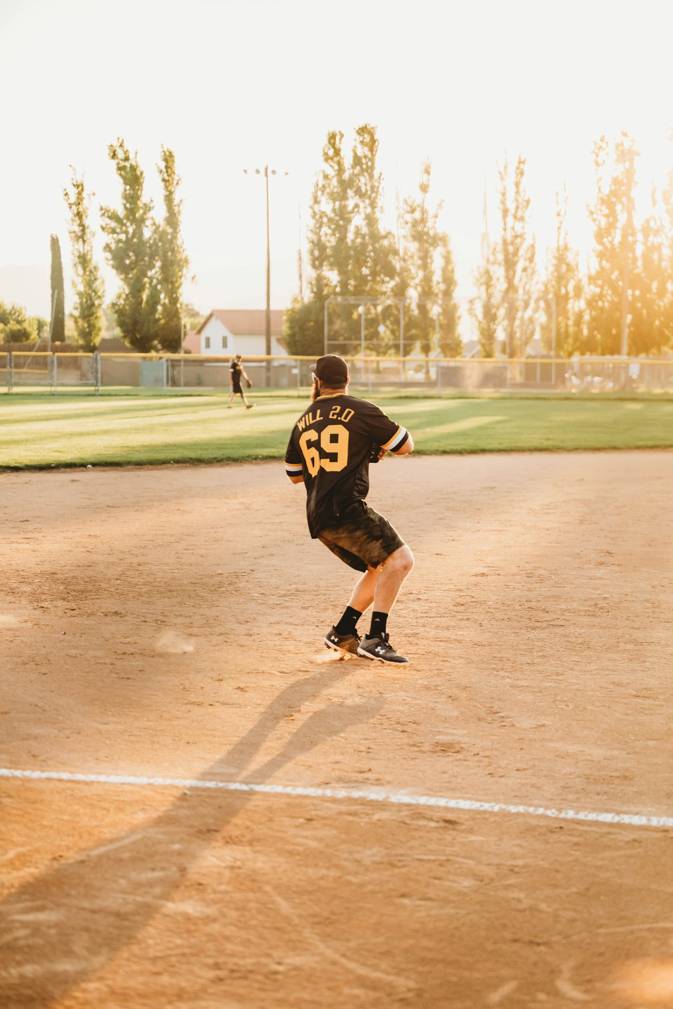 Person in a baseball jersey playing on a sunny field.
