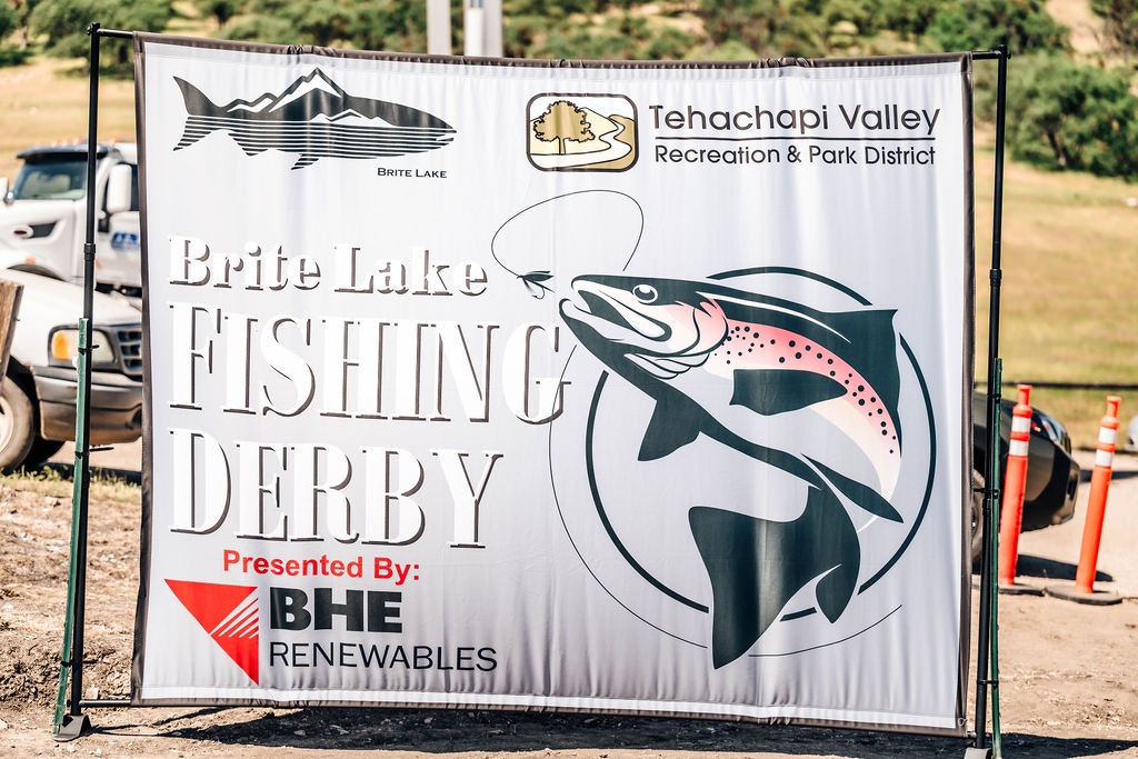 A banner for "Brite Lake Fishing Derby" sponsored by BHE Renewables in Tehachapi Valley featuring a graphic of a leaping trout.