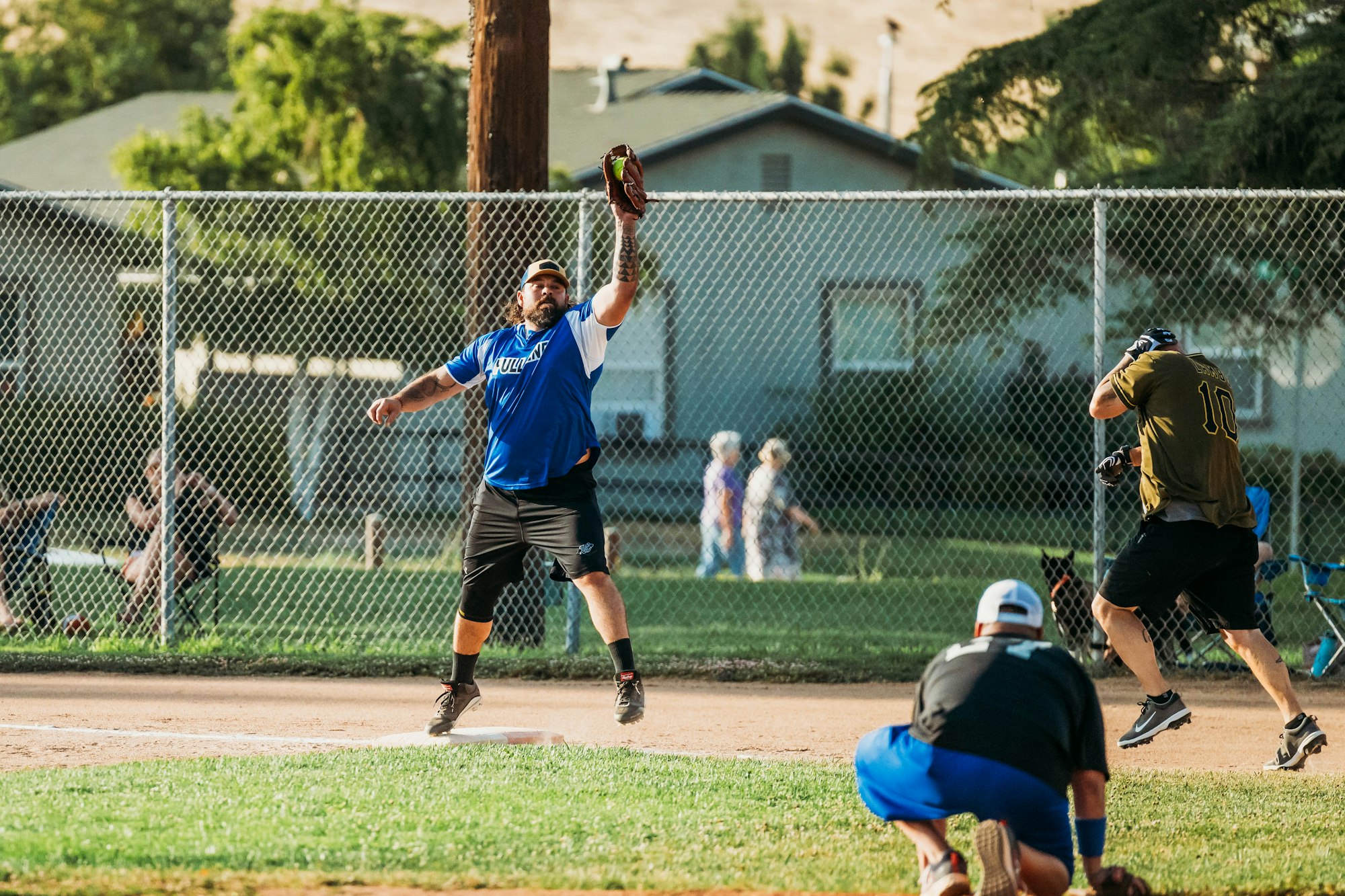 A softball game in progress with a pitcher throwing the ball and a batter ready to hit.