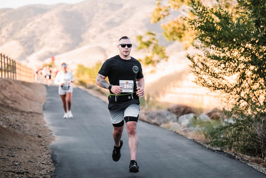People running on a path in a scenic outdoor setting.