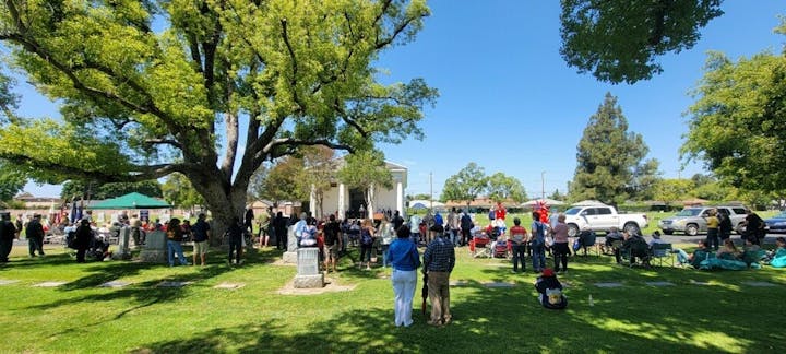 Contains people congregating in the cemetery in front of mausoleum for Memorial Day Program