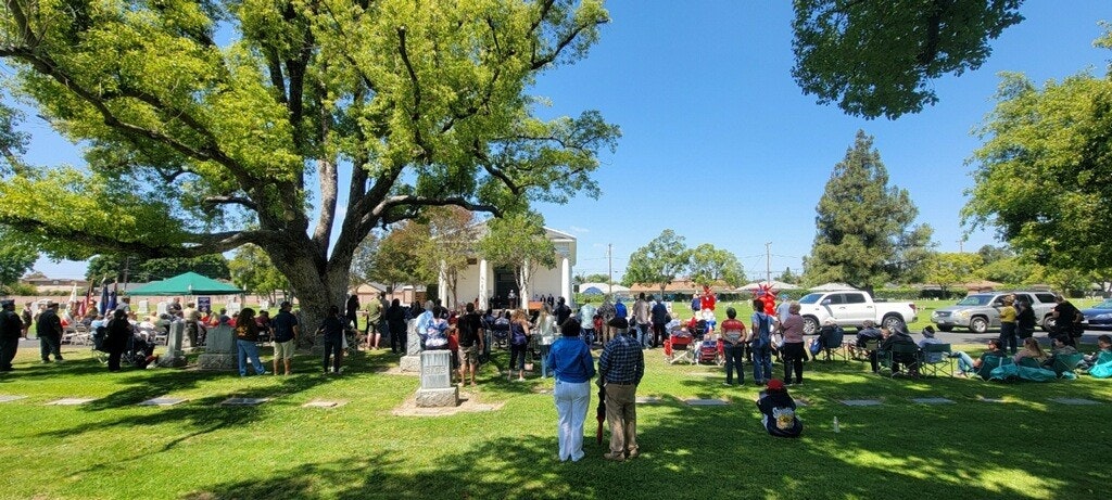 Contains people congregating in the cemetery in front of mausoleum for Memorial Day Program