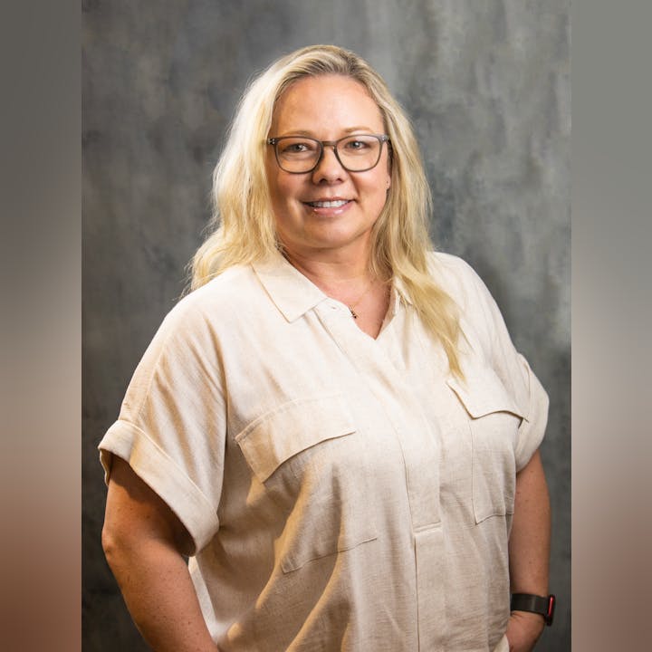 May contain: blonde, hair, person, blouse, clothing, face, happy, head, smile, adult, female, woman, photography, portrait, home decor, linen, accessories, glasses, sleeve, and wristwatch