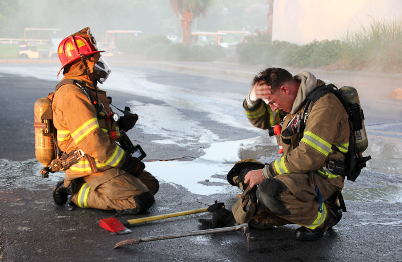 Photo of two firefighters resting after fighting a fire