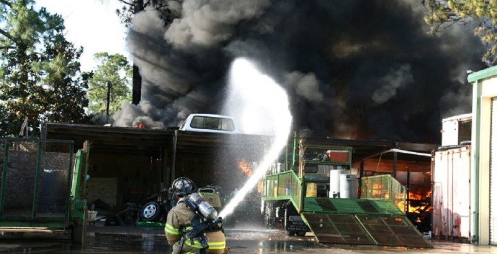 Photo of firefighter spraying a fire