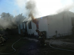 Photo of a house with smoke billowing from windows