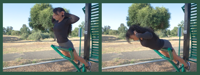 A person is exercising on outdoor fitness equipment, performing a back workout.