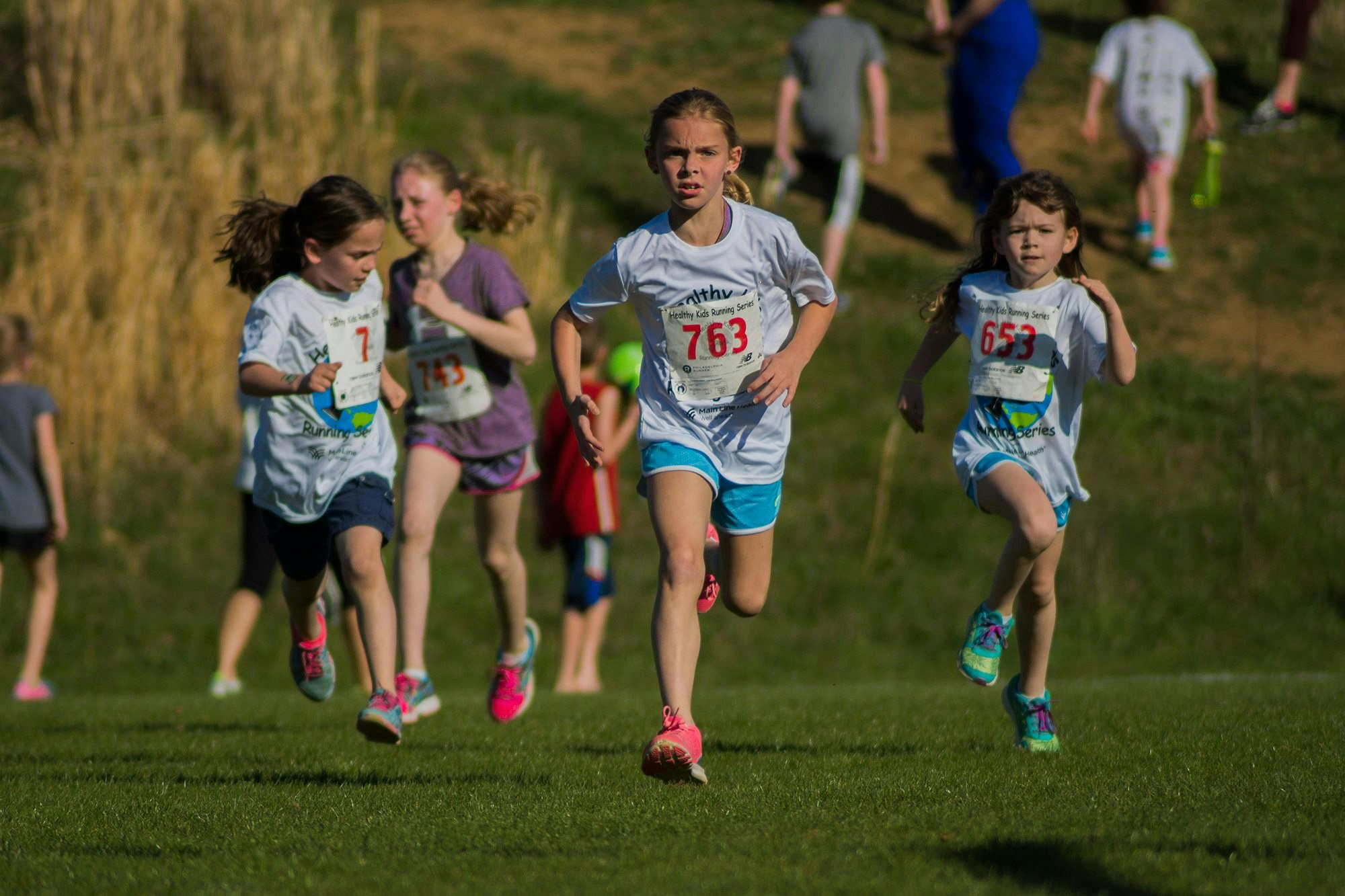 May contain: person, cross country, sport, track and field, clothing, shorts, boy, child, male, footwear, shoe, baton, and stick