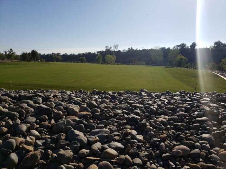 May include: rocks, grass, field, sky