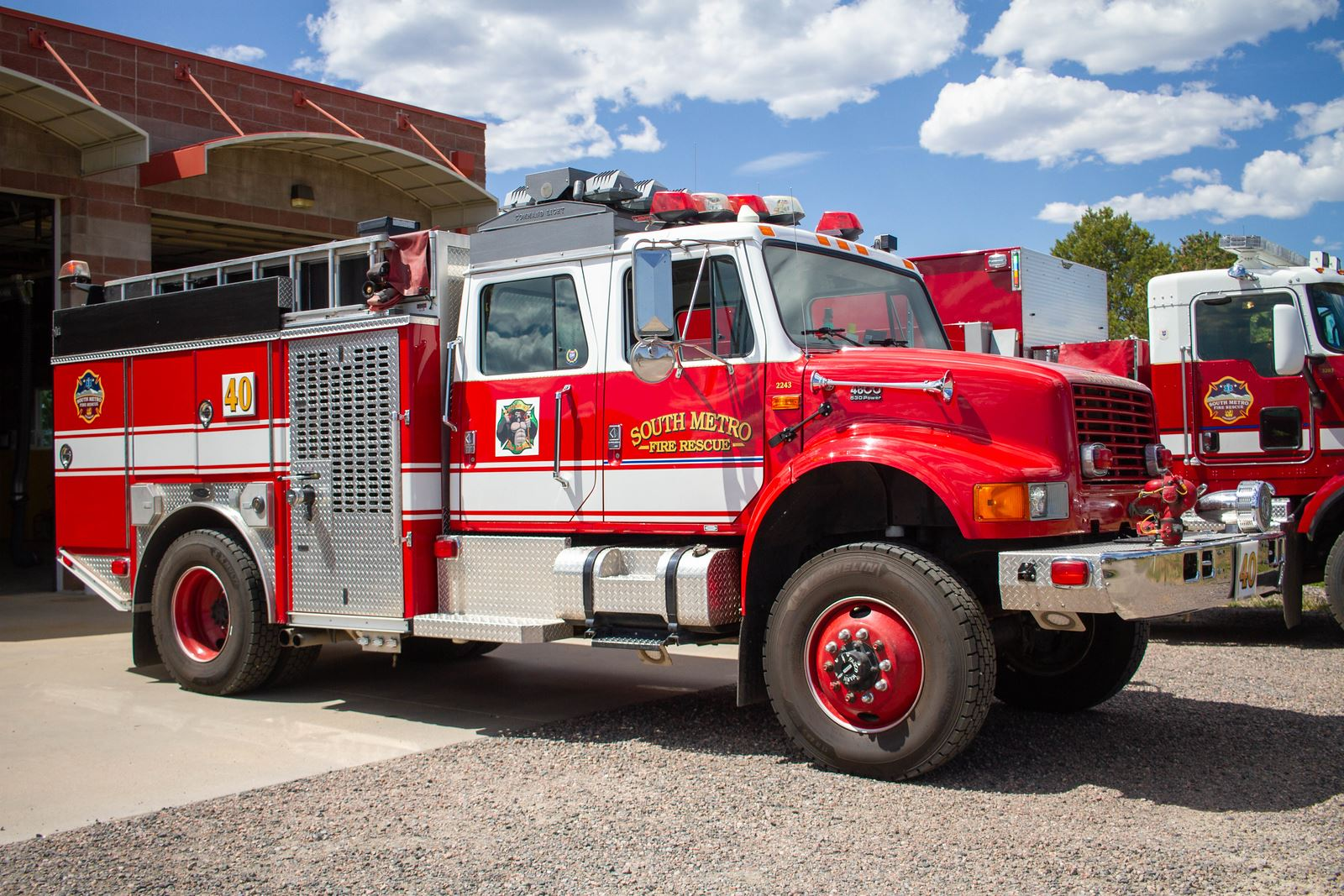 Red fire truck labeled "South Metro Fire Rescue" parked outside a fire station.