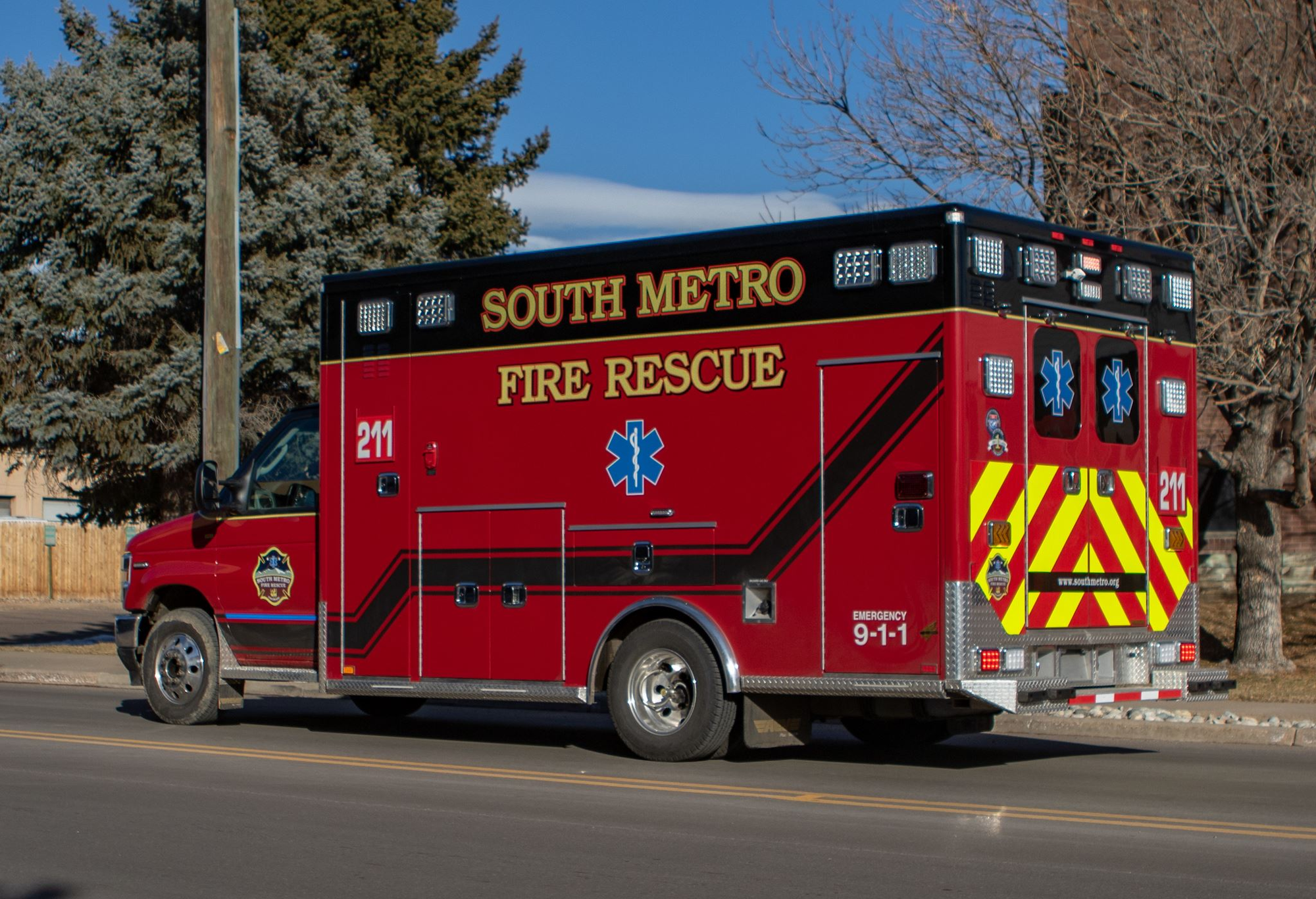Red "South Metro Fire Rescue" ambulance parked on the street.