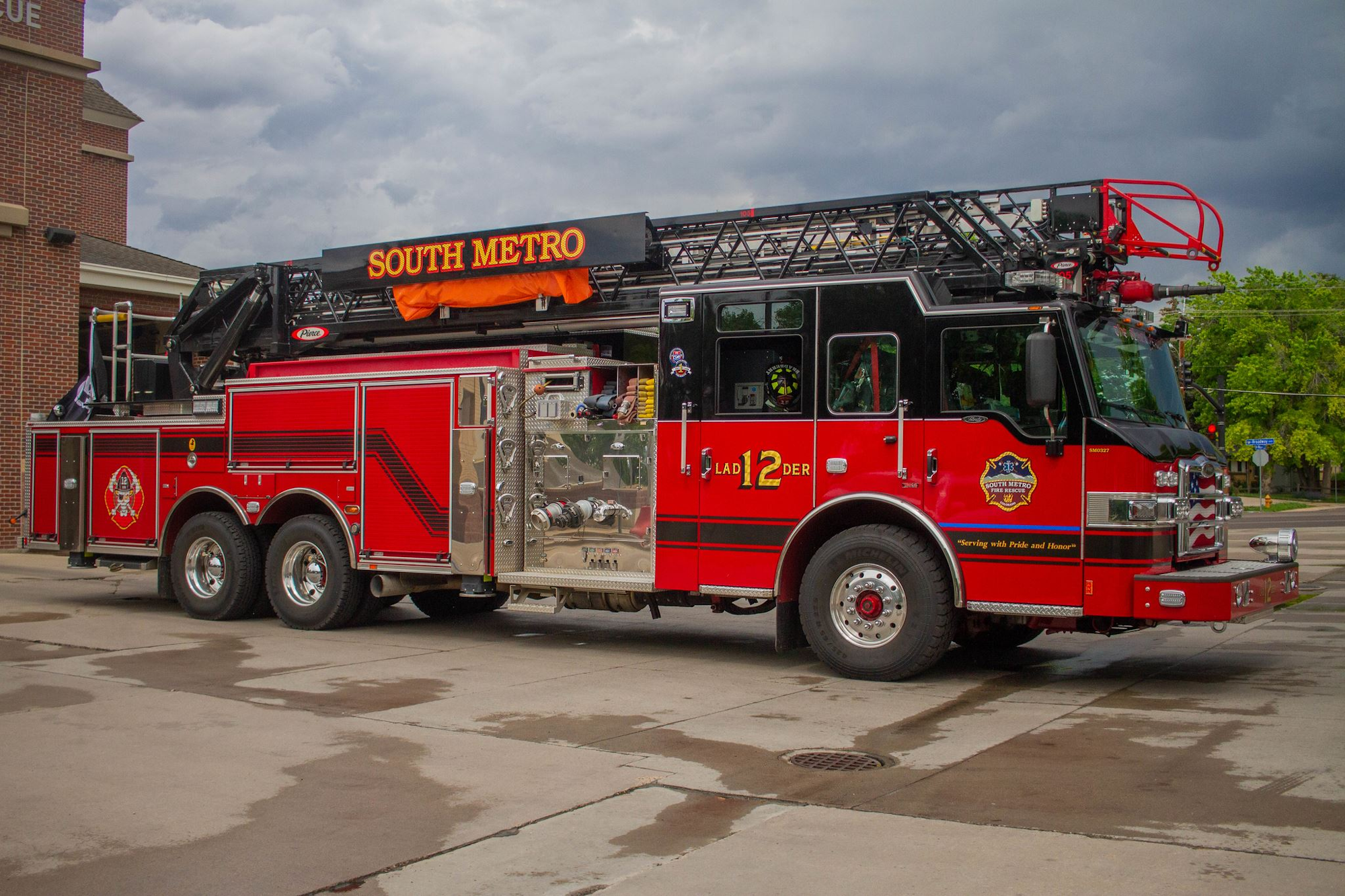 A red fire truck labeled "South Metro" with a ladder parked outside a building.