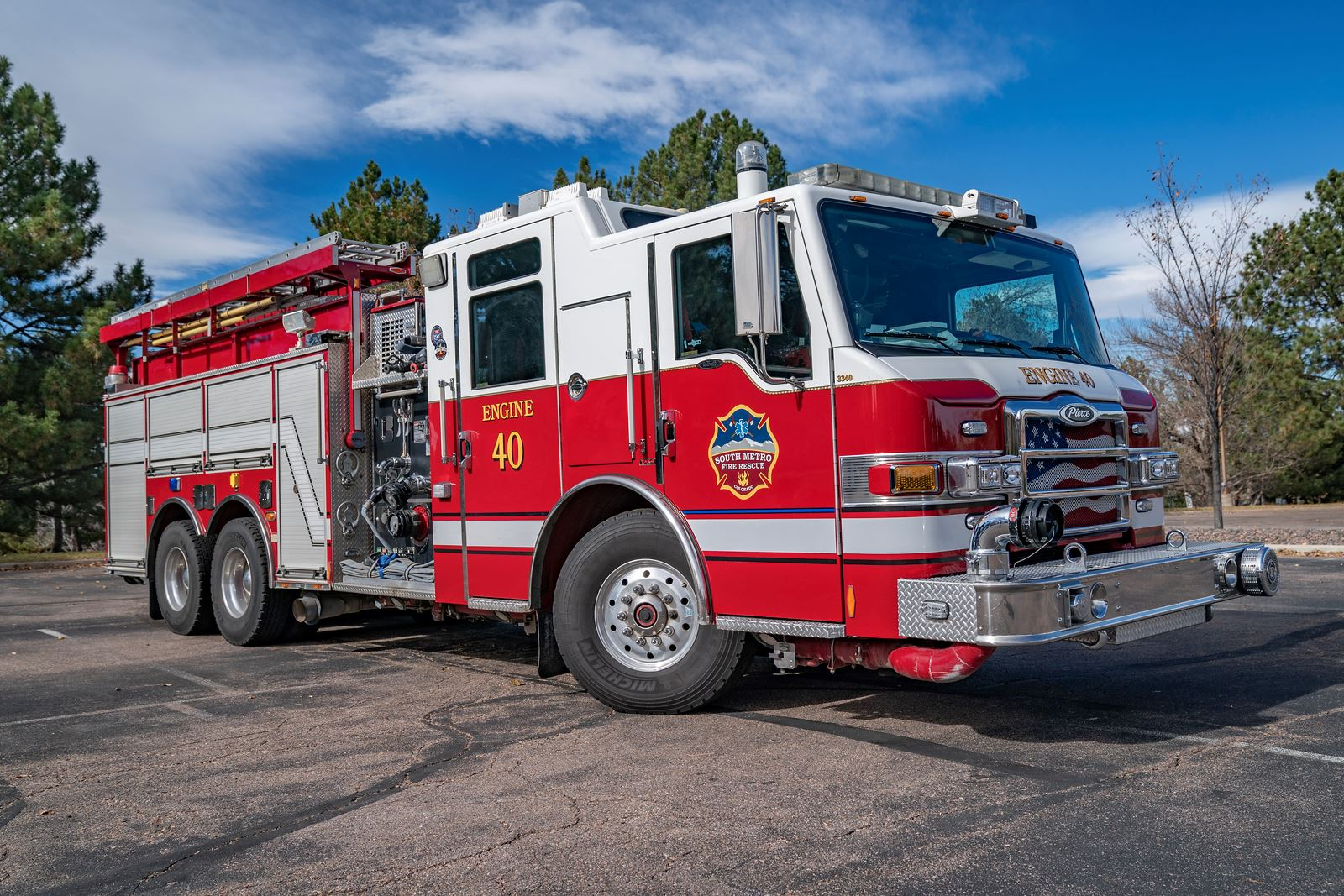 Red and white fire truck labeled "Engine 40" parked outdoors on a sunny day.