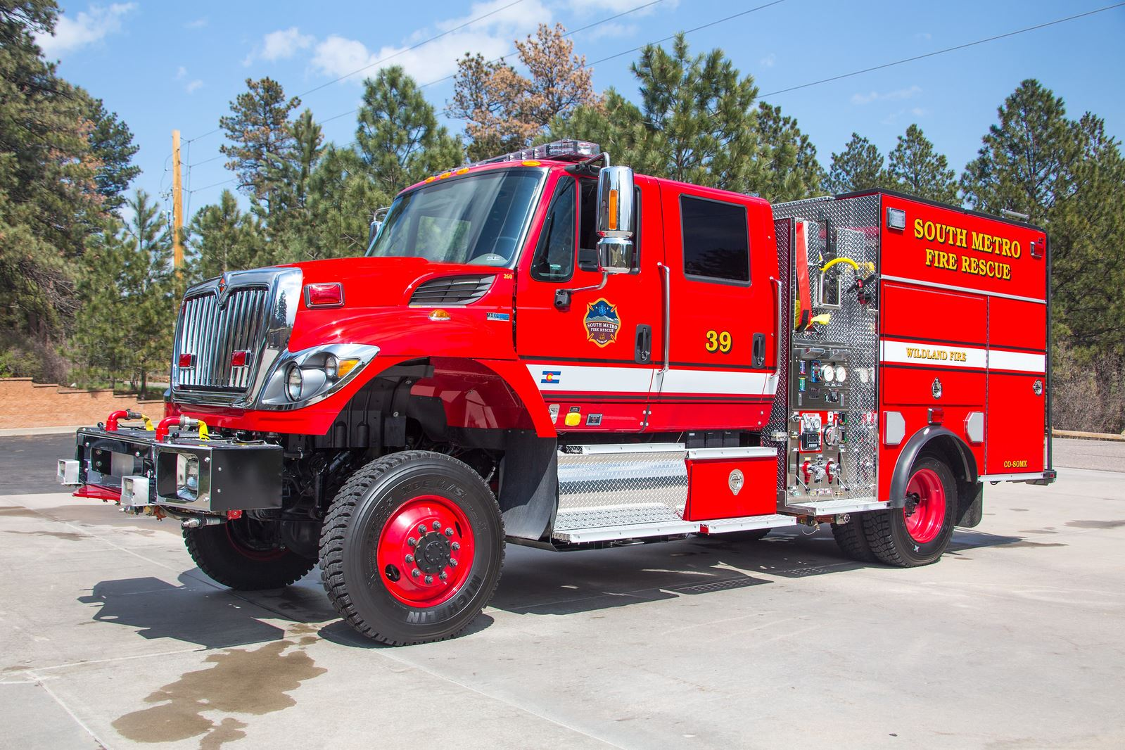 A red fire truck labeled "South Metro Fire Rescue" parked outdoors, with trees in the background.