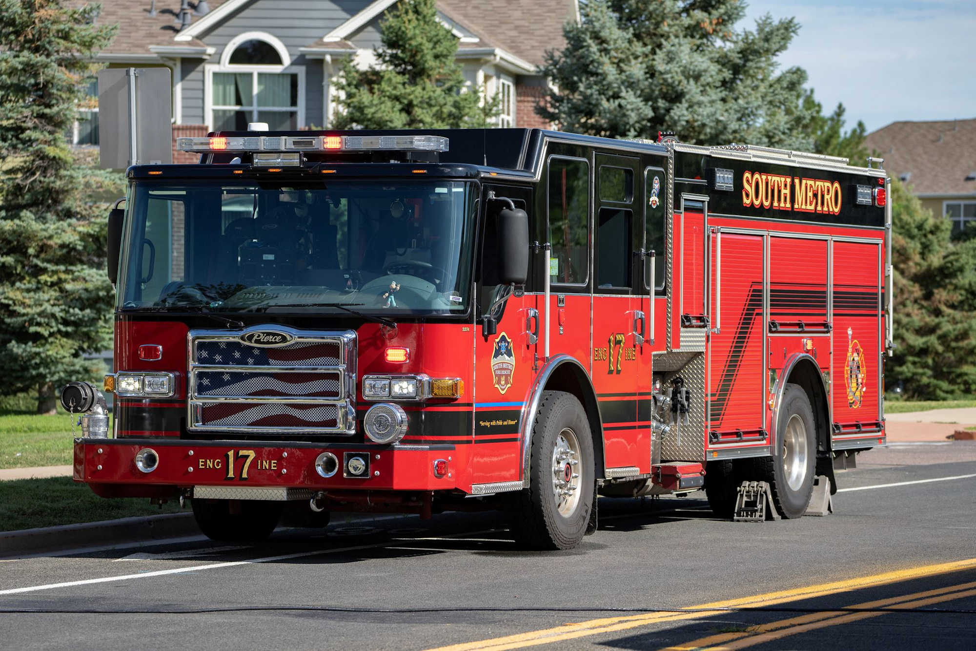 A red fire truck with "South Metro" branding is parked on a residential street.